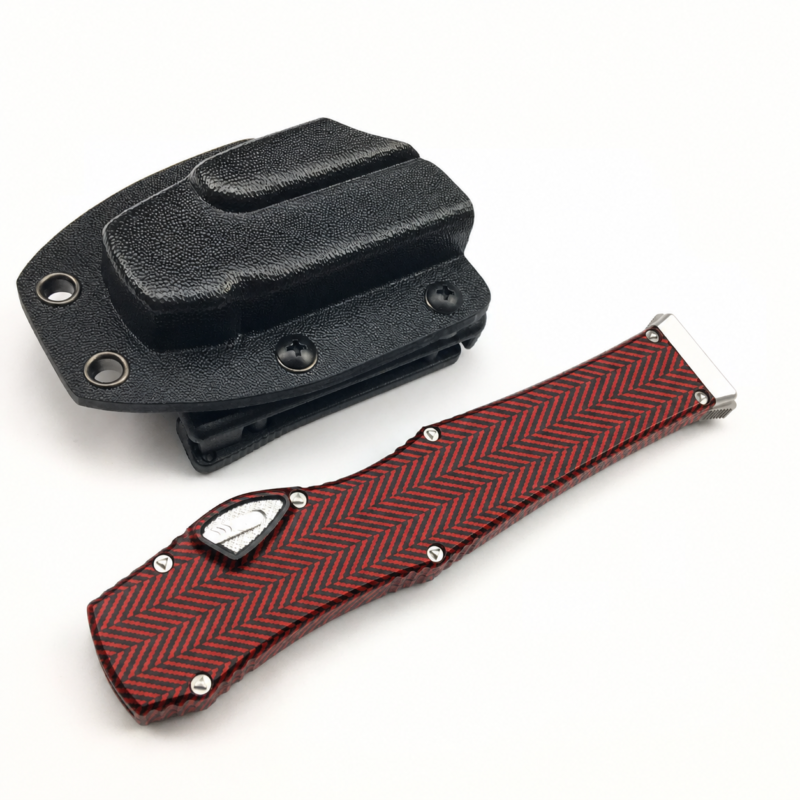 Vermilion Black Herringbone aluminum alloy OTF automatic knife closed beside a black sheath on white