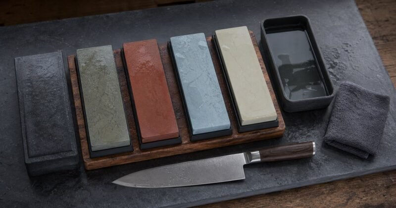 Pierre à aiguiser avec couteau de cuisine sur établi
