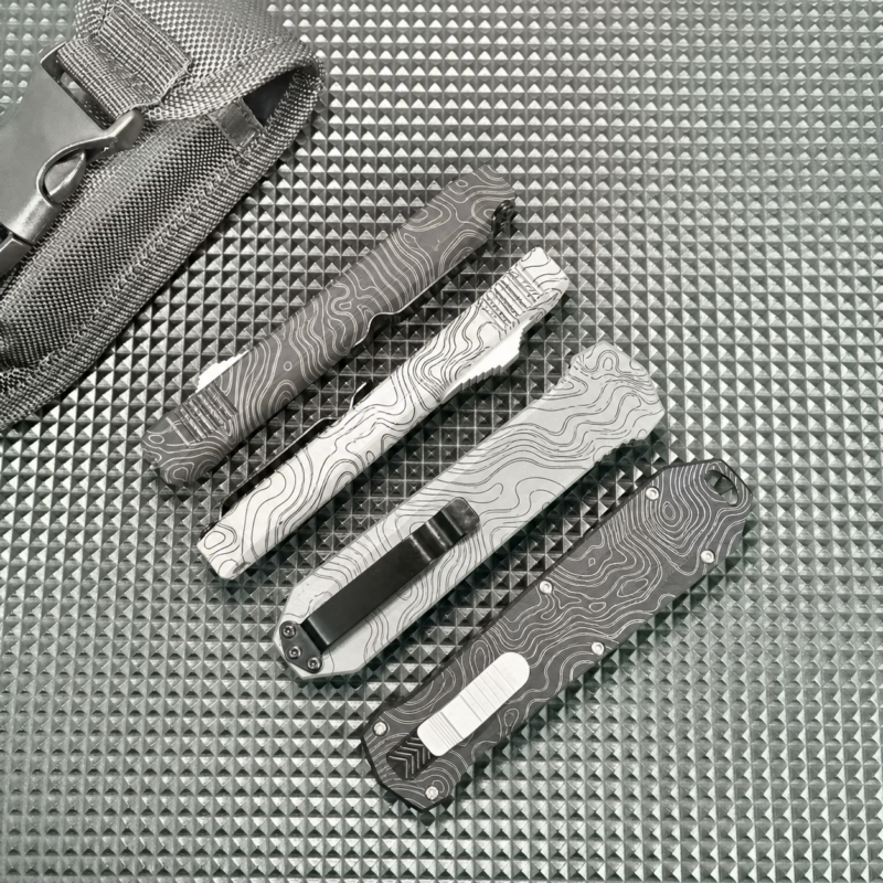 Glacier White Charcoal Topographic OTF automatic knife with face slider and hooked tail opening