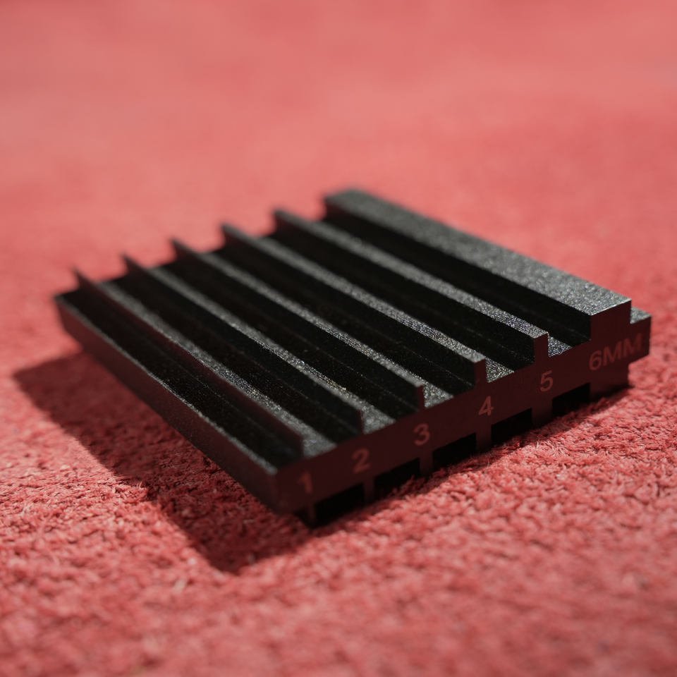 Grooved edge-beveler sharpening block with raised rails, working channels and size markings