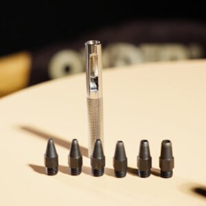 Knurled hollow leather punch handle standing behind six threaded hollow cutting tips